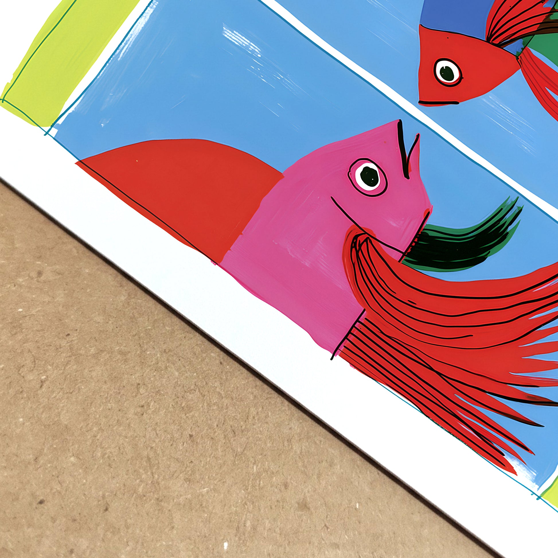 Close-up of a colourful fighting fish art print showing the paper surface, printed colour and detailed red fins against a blue and green graphic background.