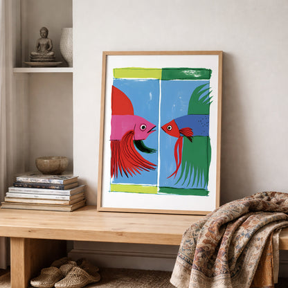 Colourful Thai betta fish print in a light wooden frame displayed on a shelf in a neutral interior with pottery, books and a textured blanket.