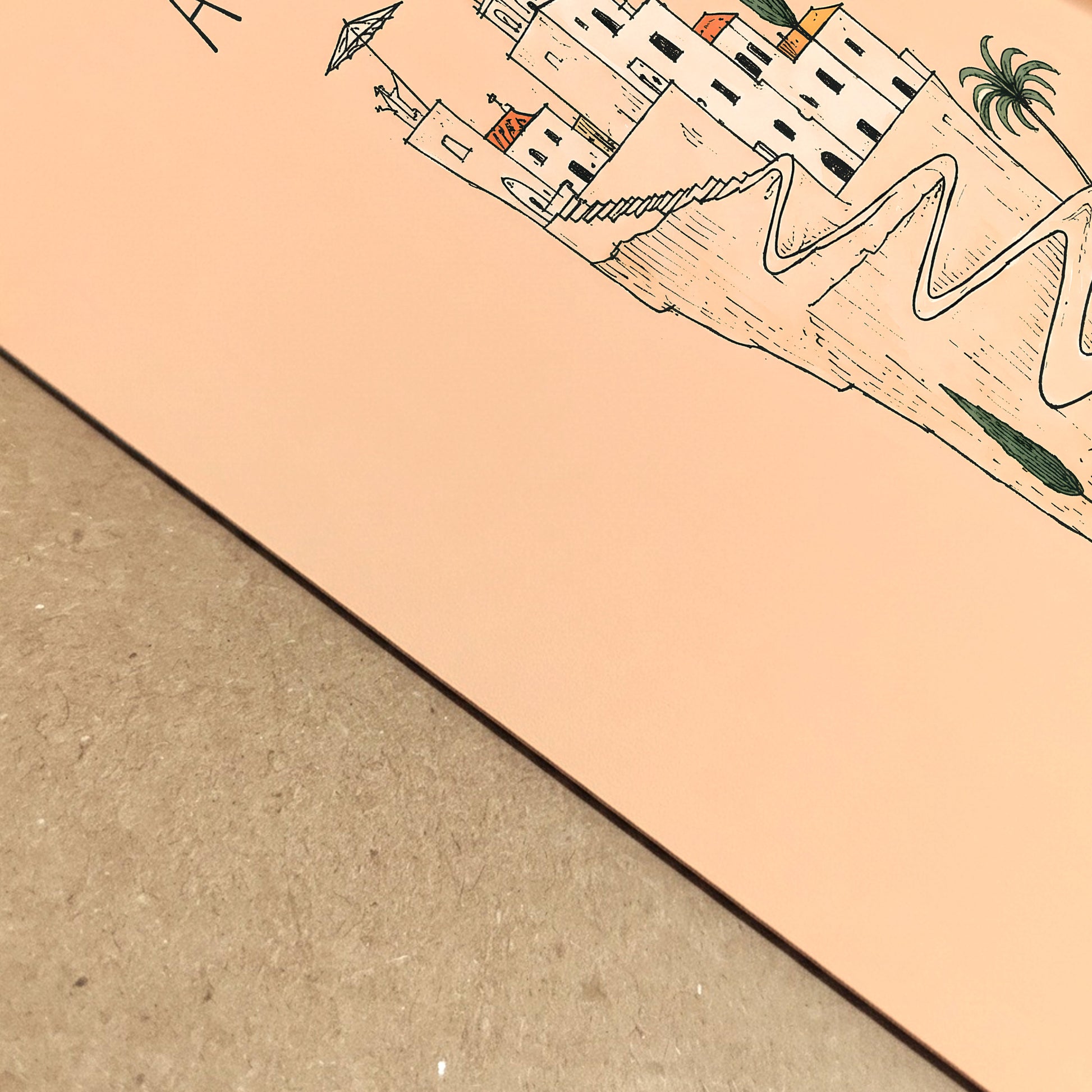 Close-up of the peach Amalfi Coast art print showing the paper surface, crisp black linework and detailed Italian cliffside village illustration.