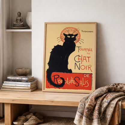 French Chat Noir poster displayed on open shelving with books and folded textiles, highlighting the black cat silhouette and red circular design. The Steinlen Art Nouveau cabaret print introduces Paris theatre heritage into a calm, textured interior. A strong vintage French wall art choice for creative studios, reading spaces or cultural home decor.