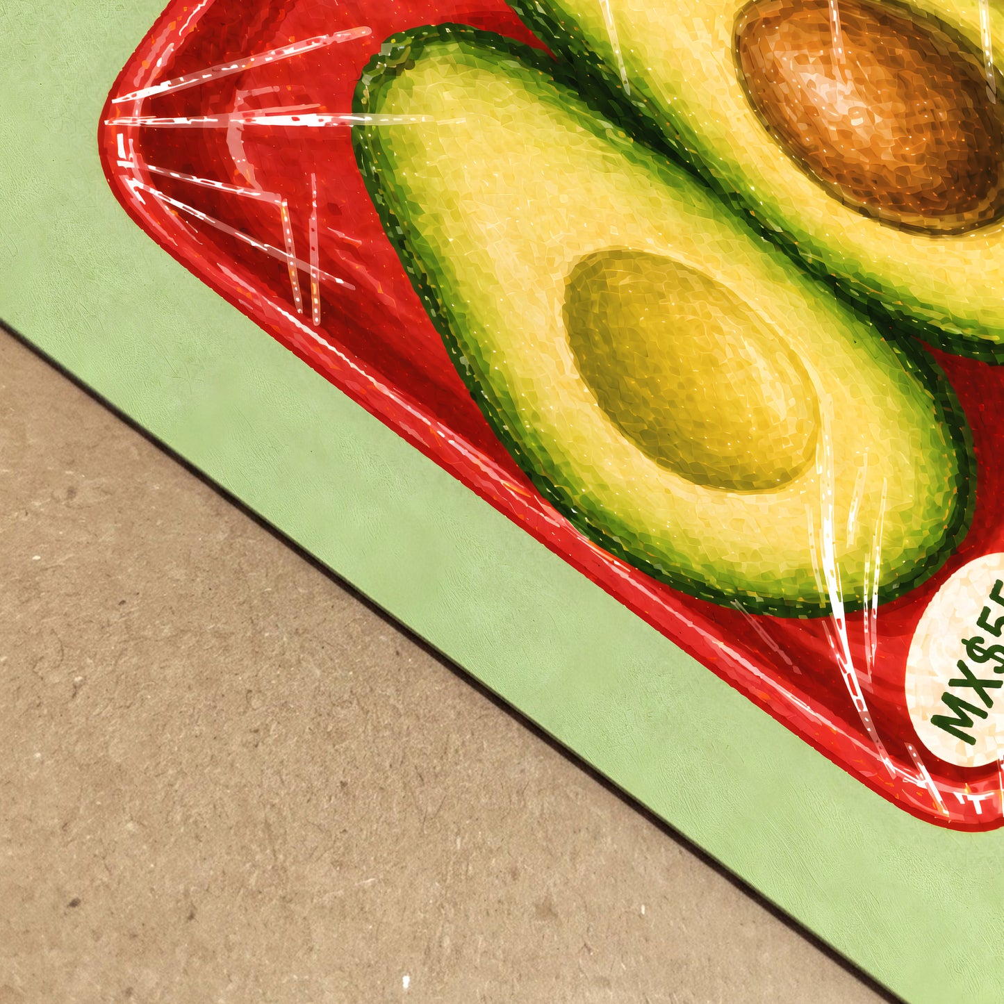 Close-up of the Mexican avocado print resting on a natural surface, showing the paper edge, textured red produce tray, green avocado halves and clear packaging lines.