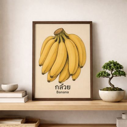 Framed banana print displayed on a shelf against a light neutral wall, styled with a small bonsai-style plant and simple home decor. The vintage Thai fruit artwork adds colour without looking too busy, with the yellow bananas and aged background keeping the look soft and easy to place. This mockup is useful for kitchen wall art, pantry decor, fruit wall print, and rustic or modern shelf styling searches.