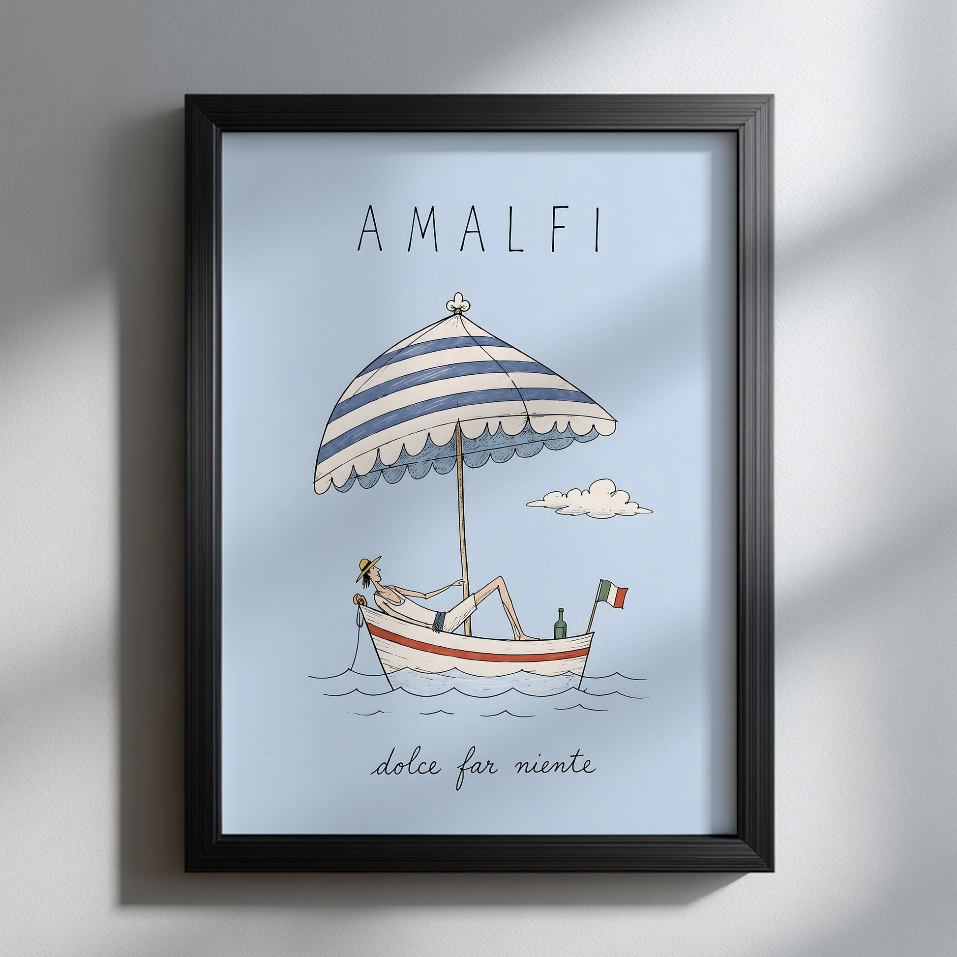 Amalfi summer boat wall art displayed facing forward in a black frame on a white wall, with natural window shadows highlighting the pale blue Italian travel print.