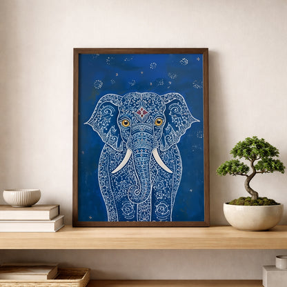 Framed Blue Elegant Elephant Print placed on a light wood shelf beside a bonsai-style plant and simple neutral decor. The artwork shows a front-facing elephant with fine white linework, gold eyes, white tusks and a deep blue background. A calm mockup for elephant wall art, blue elephant print, Indian-inspired animal art and modern shelf styling in a bedroom or home office.