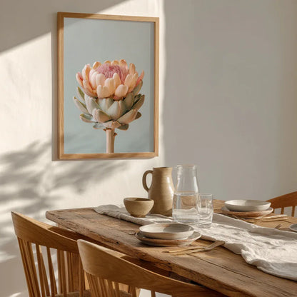 A pastel artichoke wall art print hanging above a styled dining table with warm natural light. Contemporary home décor, soft textures and neutral tones emphasise the artwork’s gentle colour palette and botanical detail.