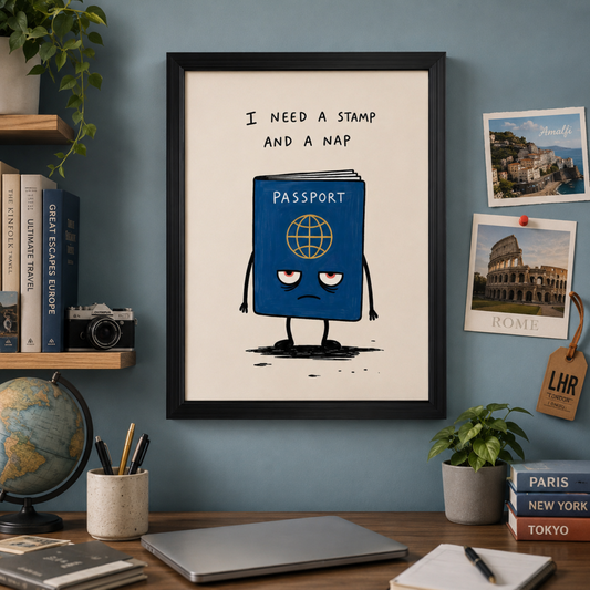 Framed funny travel poster displayed in a colourful office space with travel books, postcards, a globe, plants, camera and desk accessories. The artwork shows a tired blue passport character under the quote “I need a stamp and a nap”, making it ideal travel office decor and passport wall art.