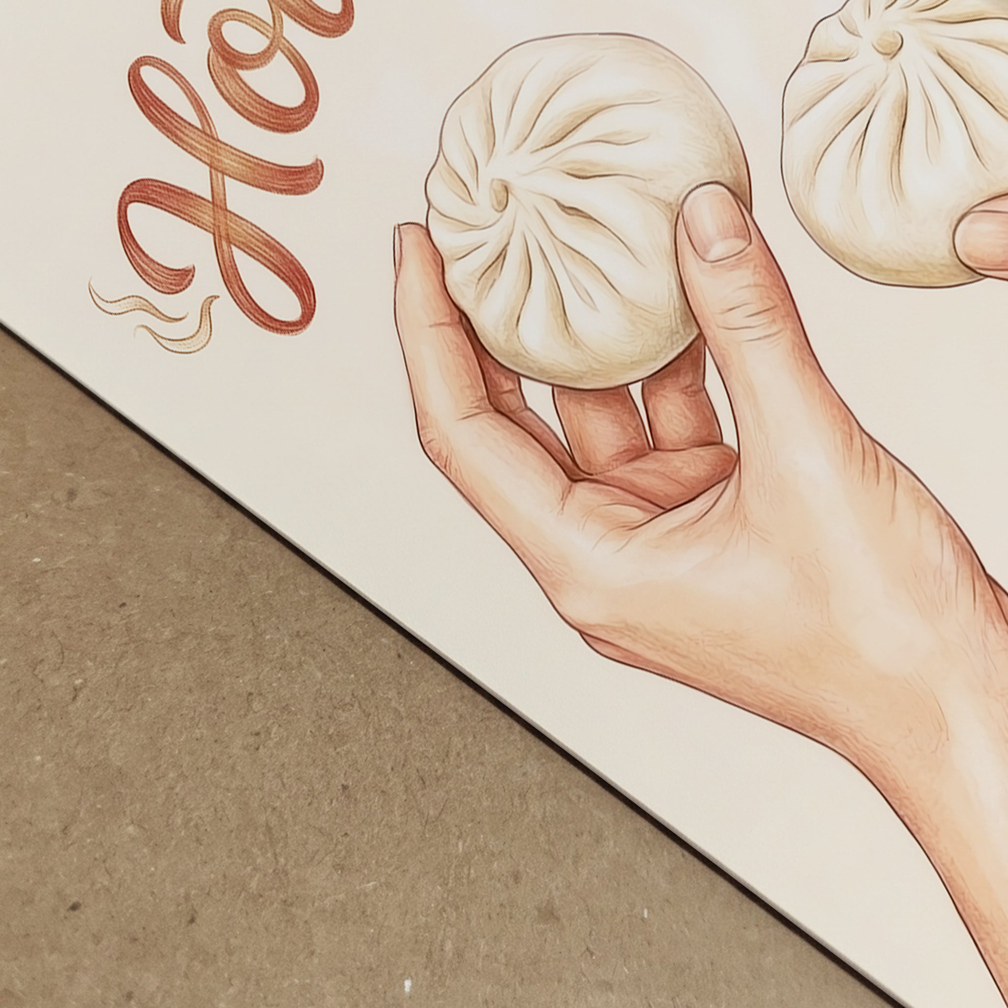Angled close-up of the Hot Buns print showing part of the lettering and one hand holding a steamed bun, photographed to highlight paper detail and print finish. The beige background, brown script, and hand drawn food illustration create a simple modern look. A strong image for showing asian food wall art, food pun print detail, and the clean finish of kitchen wall decor.