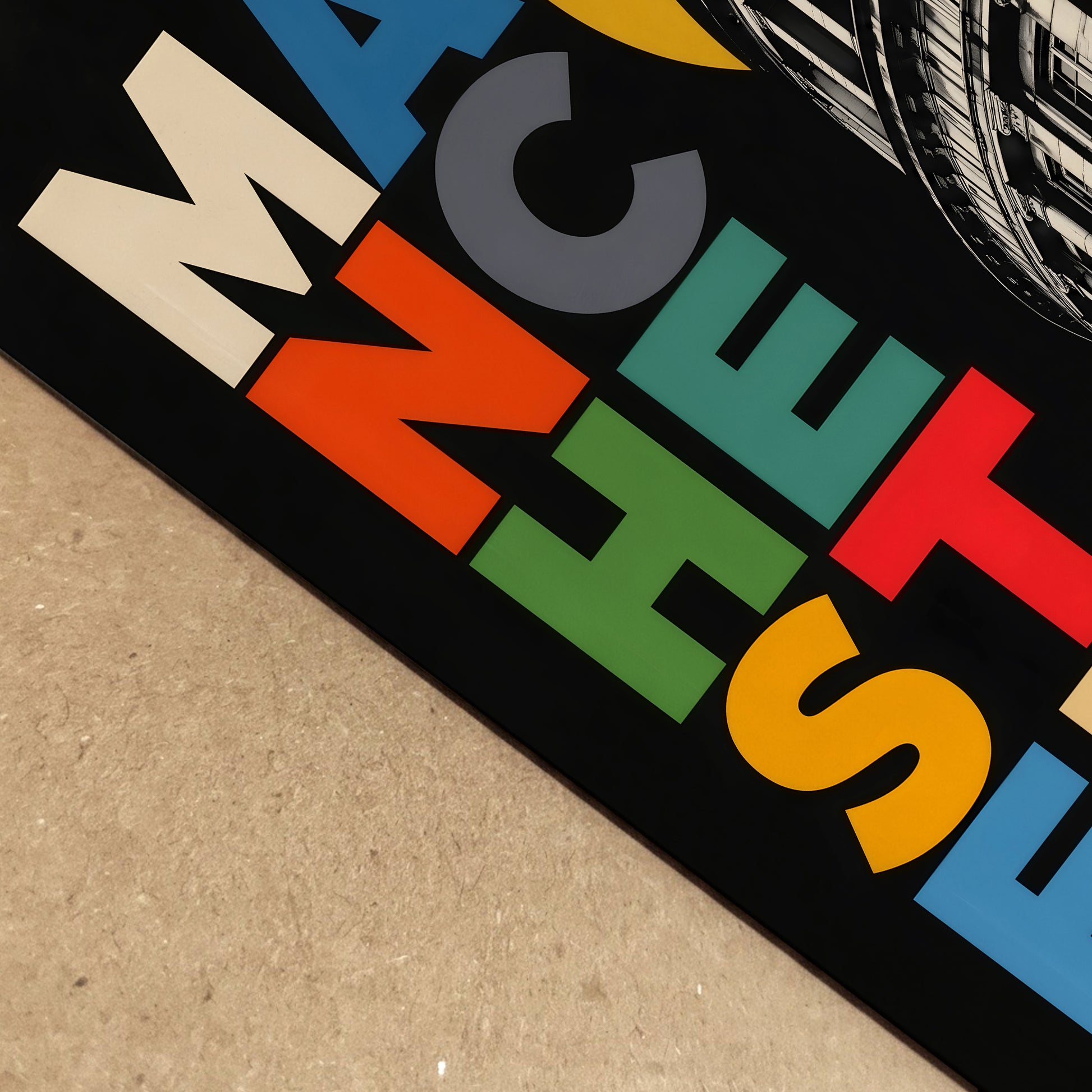 Close-up of the Manchester Central Library print lying on a textured surface, showing crisp coloured lettering, a deep black background and detailed architectural linework.