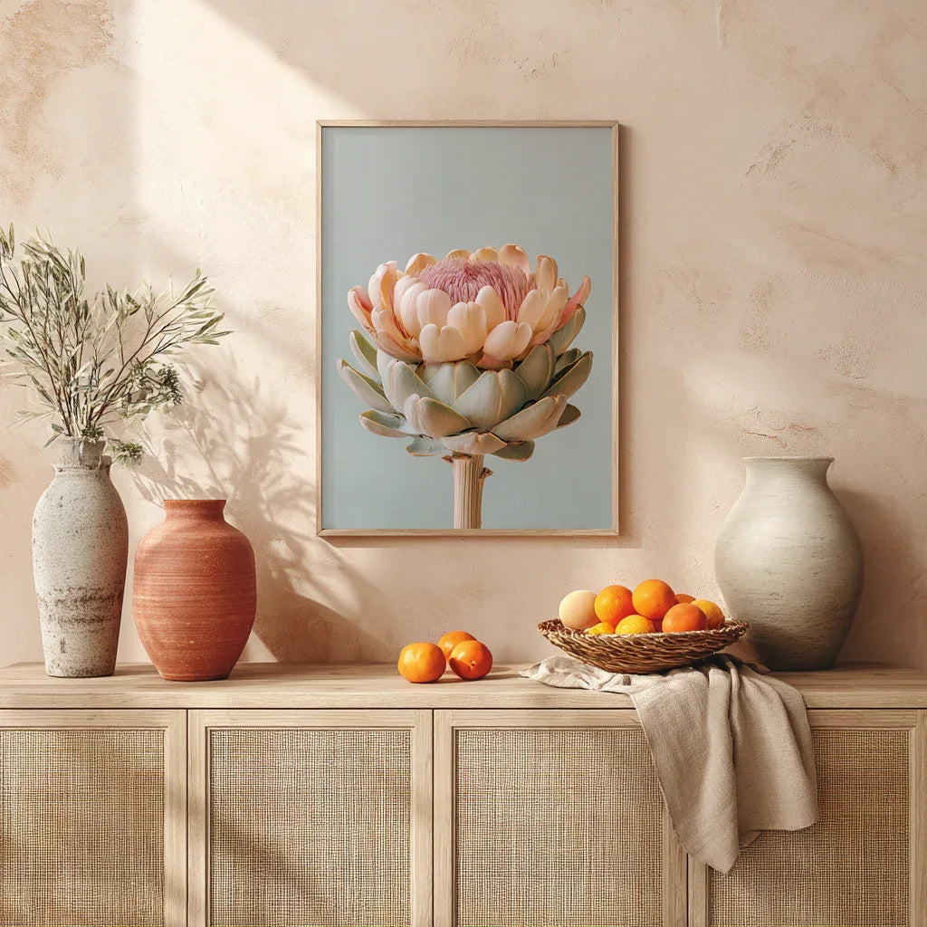 A pastel artichoke wall art print styled above a mantle with decorative vases and warm daylight. Natural textures and earthy neutrals enhance the artwork’s soft botanical palette and contemporary interior aesthetic.