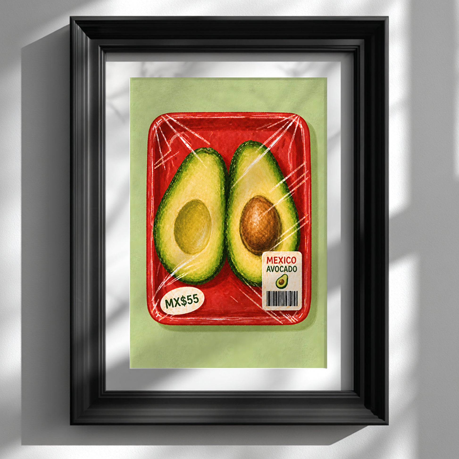 Mexican avocado kitchen print in a deep black frame with a white mount, displayed on a white wall with strong natural sunlight and diagonal shadows.