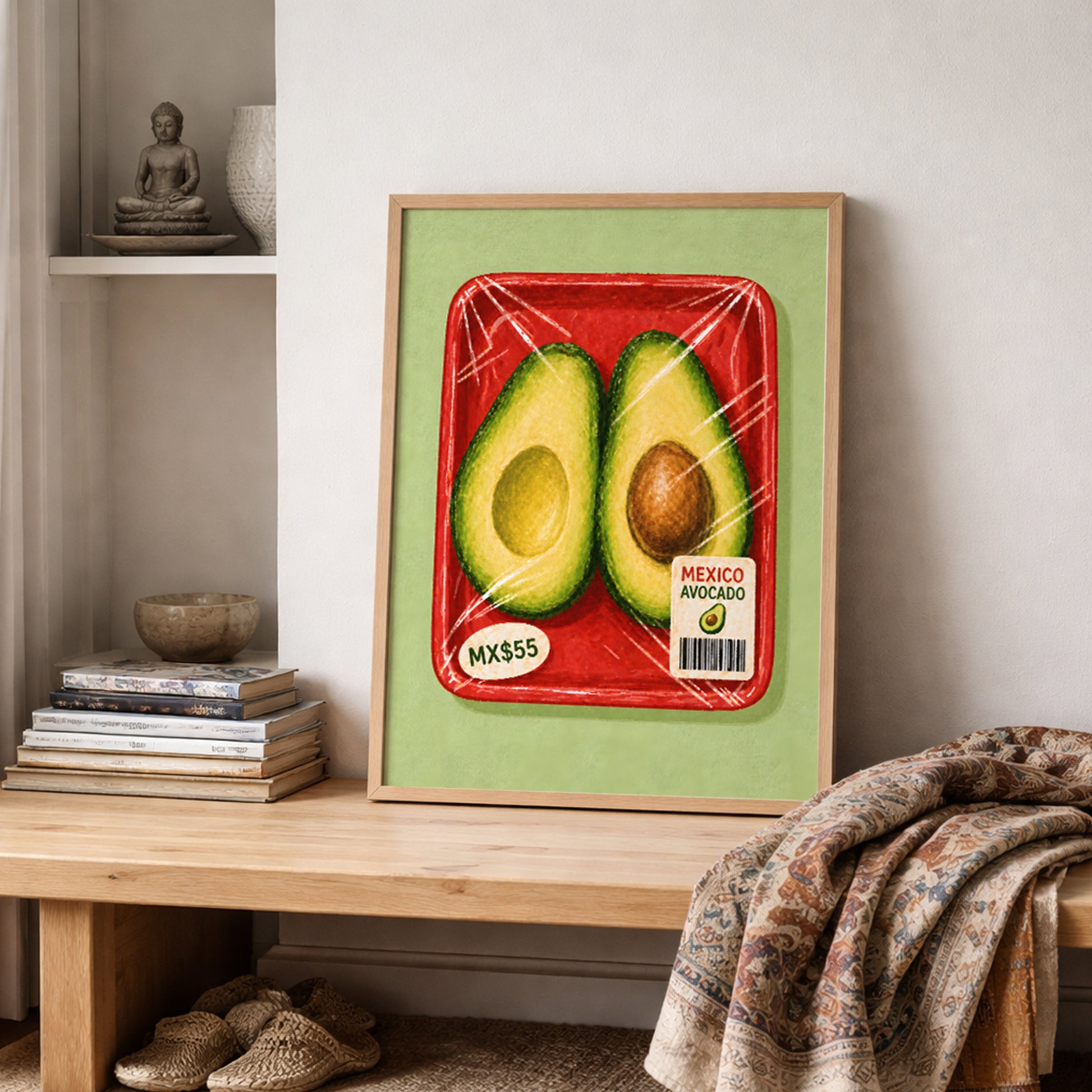 Mexican avocado wall art in a wooden frame on a shelf with stacked books, a woven textile and warm neutral decor, styled as a lived-in kitchen or dining space.