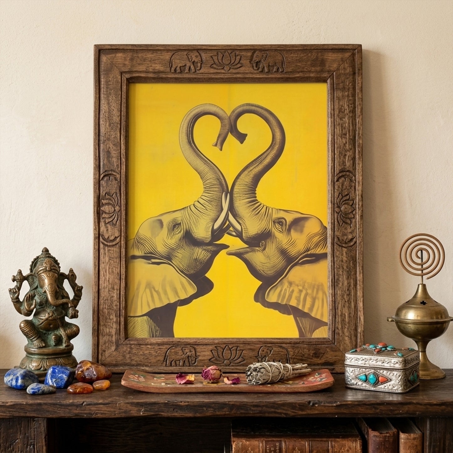 Elephant Heart framed elephant wall art shown in a warm travel-inspired interior with an ornate wooden frame, decorative objects, and a rich cultural styling setup. The yellow elephant print features two mirrored elephants with trunks forming a heart. Lifestyle image for elephant poster, framed elephant print, asian elephant wall art, thai elephant art, and cultural wall decor.