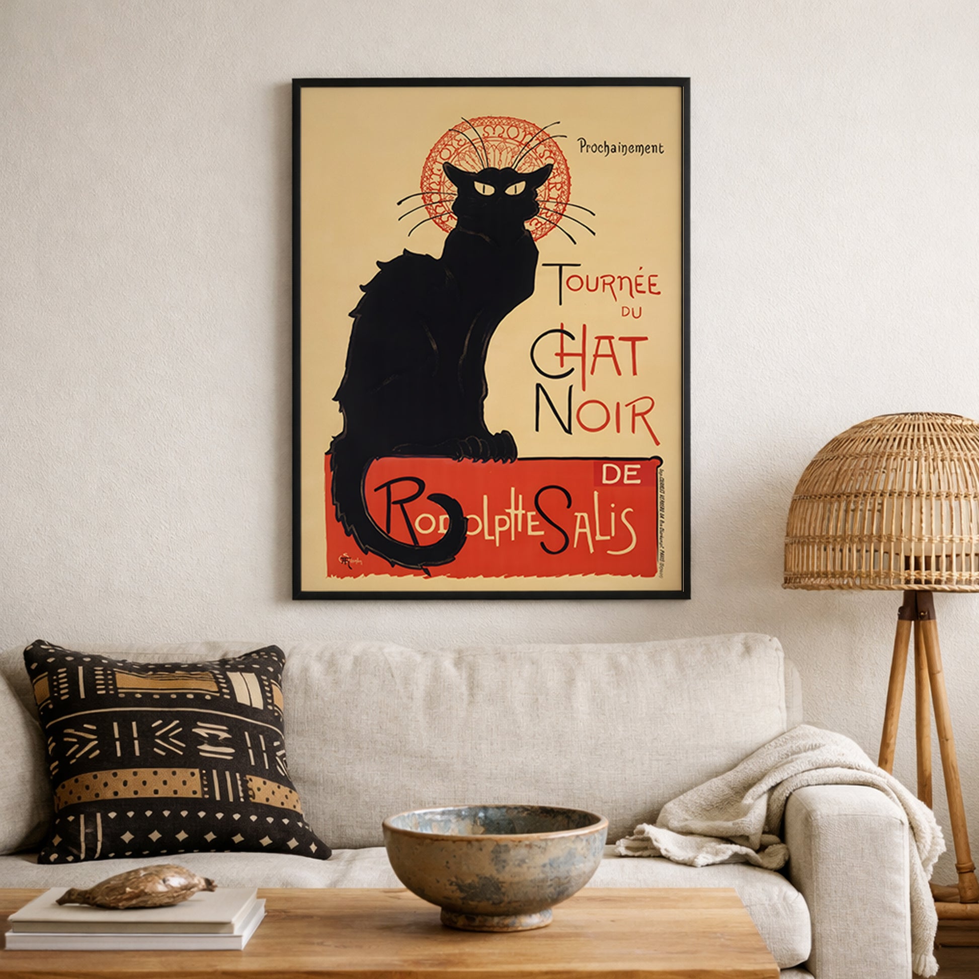 Framed Tournée du Chat Noir print mounted above a sofa in a neutral living room. The iconic black cat and bold red typography create a defined focal point within modern decor. This French Art Nouveau theatre poster pairs with woven textures and minimalist furniture, offering classic Paris wall art with timeless vintage graphic design appeal.