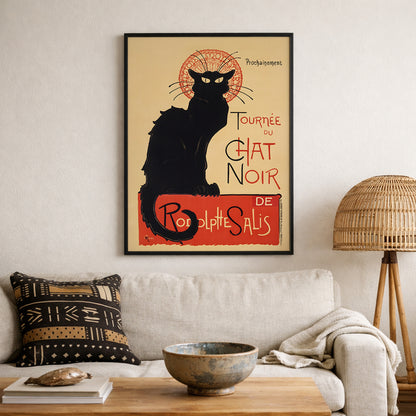 Framed Tournée du Chat Noir print mounted above a sofa in a neutral living room. The iconic black cat and bold red typography create a defined focal point within modern decor. This French Art Nouveau theatre poster pairs with woven textures and minimalist furniture, offering classic Paris wall art with timeless vintage graphic design appeal.