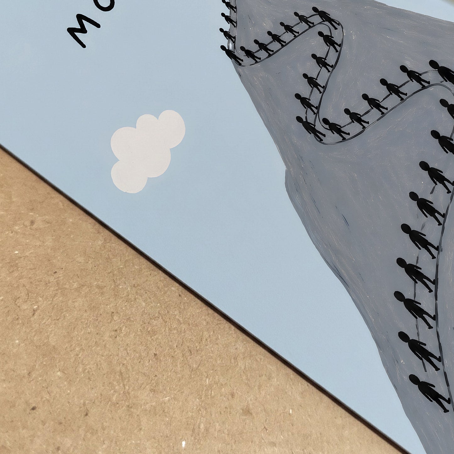 Close-up detail of the Queue Mountain poster printed on paper, showing the pale blue background, grey mountain edge, cream cloud and part of the winding line of tiny hikers. The angled view highlights the clean illustrated texture and modern funny hiking print style for outdoor and travel themed wall art.
