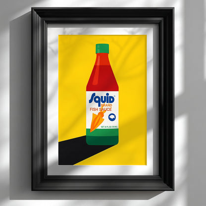 Framed Squid Fish Sauce pop art poster displayed on a white wall in a glossy black frame. The artwork shows a stylised Thai fish sauce bottle on a bold yellow background with strong graphic shapes and clean lines. This kitchen wall art mockup highlights the bright colour contrast, modern food poster style and pop art print look, making it ideal for Thai kitchen decor, food art lovers and contemporary gallery walls.