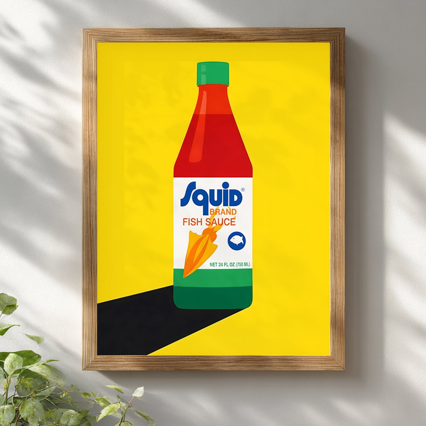 Squid Fish Sauce pop art poster displayed in a light wooden frame on a white wall with soft natural shadows. The print shows a stylised Thai fish sauce bottle on a bold yellow background, creating a bright modern statement. This framed food poster mockup highlights the artwork as contemporary kitchen wall art, Thai pantry decor and colourful pop art print suited to clean interiors, dining spaces and minimalist gallery walls.