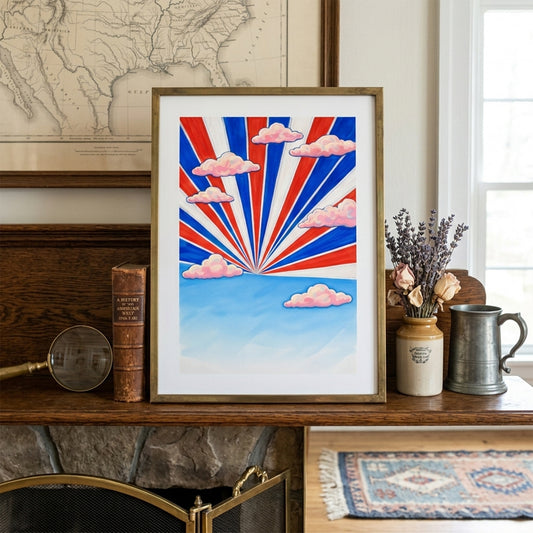 Thailand travel poster featuring a red, white and blue sunburst design displayed on a mantle shelf. Pink clouds and blue sky create a bold graphic look inspired by the Thai flag. Framed Southeast Asia wall art styled with neutral decor for a modern living room setting.