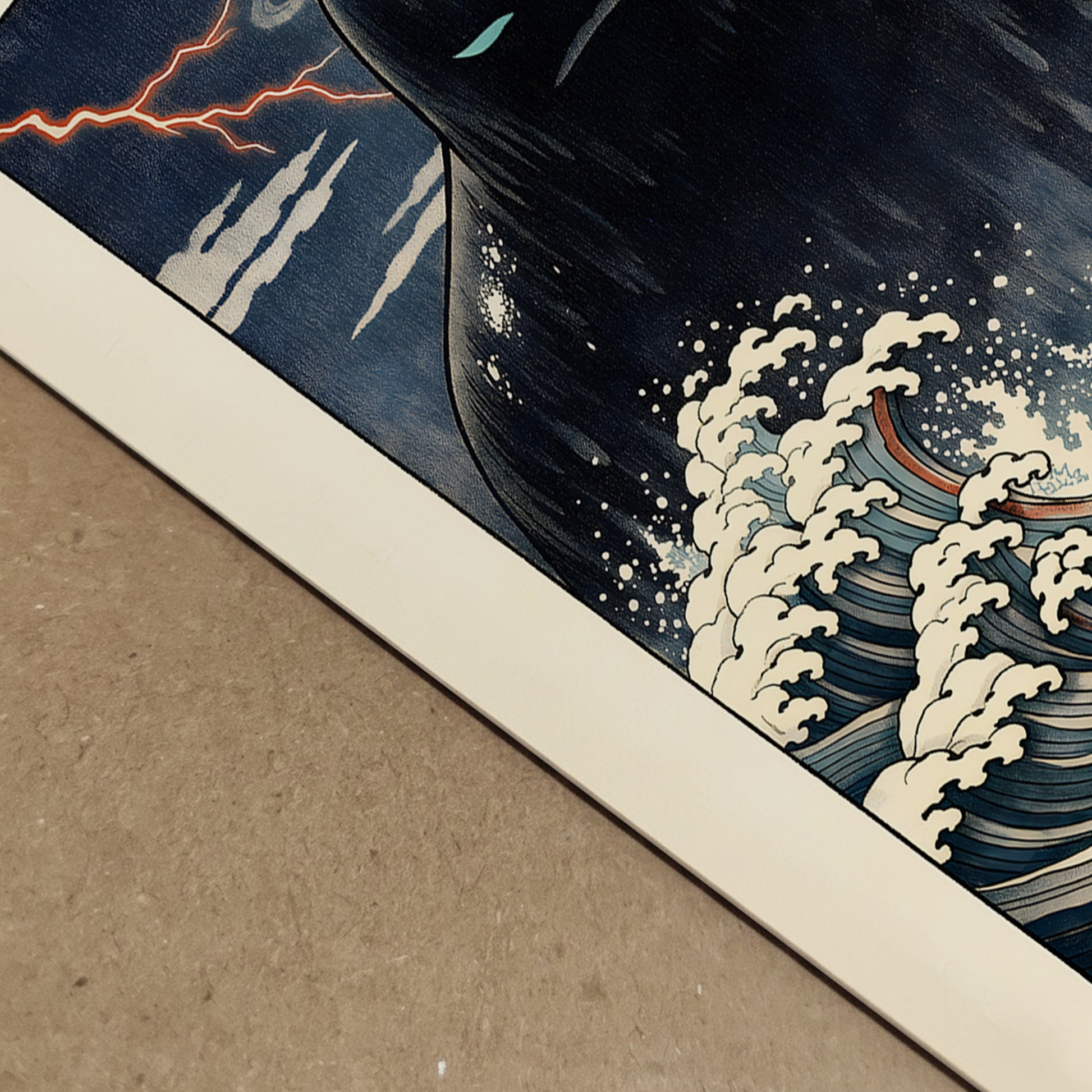 Close-up detail of the Japanese Umibōzu wave art print showing textured paper surface, cream wave foam and deep navy ink tones. The angled perspective highlights print quality, edge finish and fine line detailing inspired by traditional woodblock aesthetics. A premium folklore poster showcasing crisp colour contrast and detailed ocean illustration.