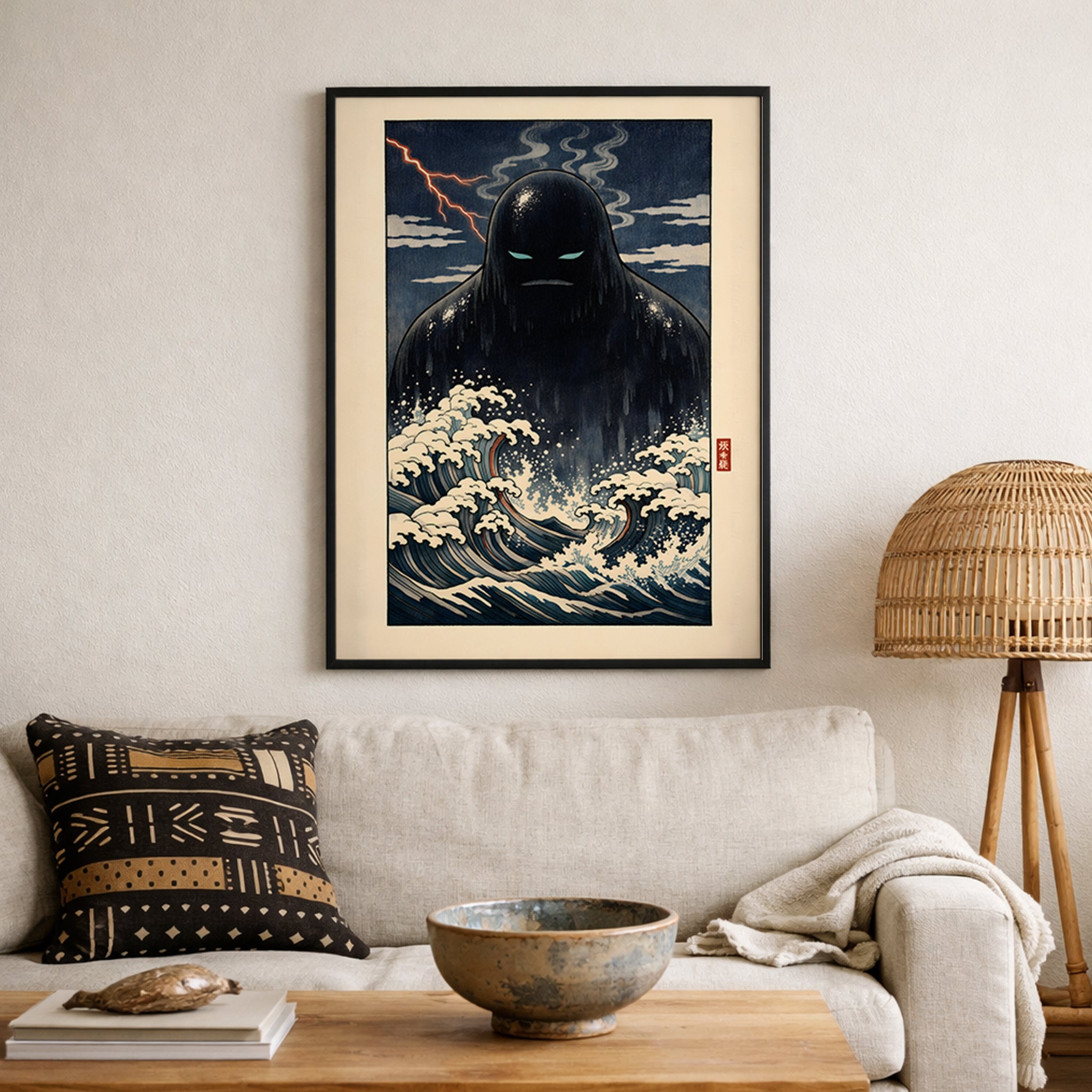 Framed Japanese folklore wall art featuring the Umibōzu sea monk hanging above a neutral sofa in a softly styled living room. The print showcases dramatic navy waves, cream foam details and a looming shadowed figure beneath a stormy sky. A bold yōkai-inspired statement piece blending traditional ocean motifs with modern home decor.