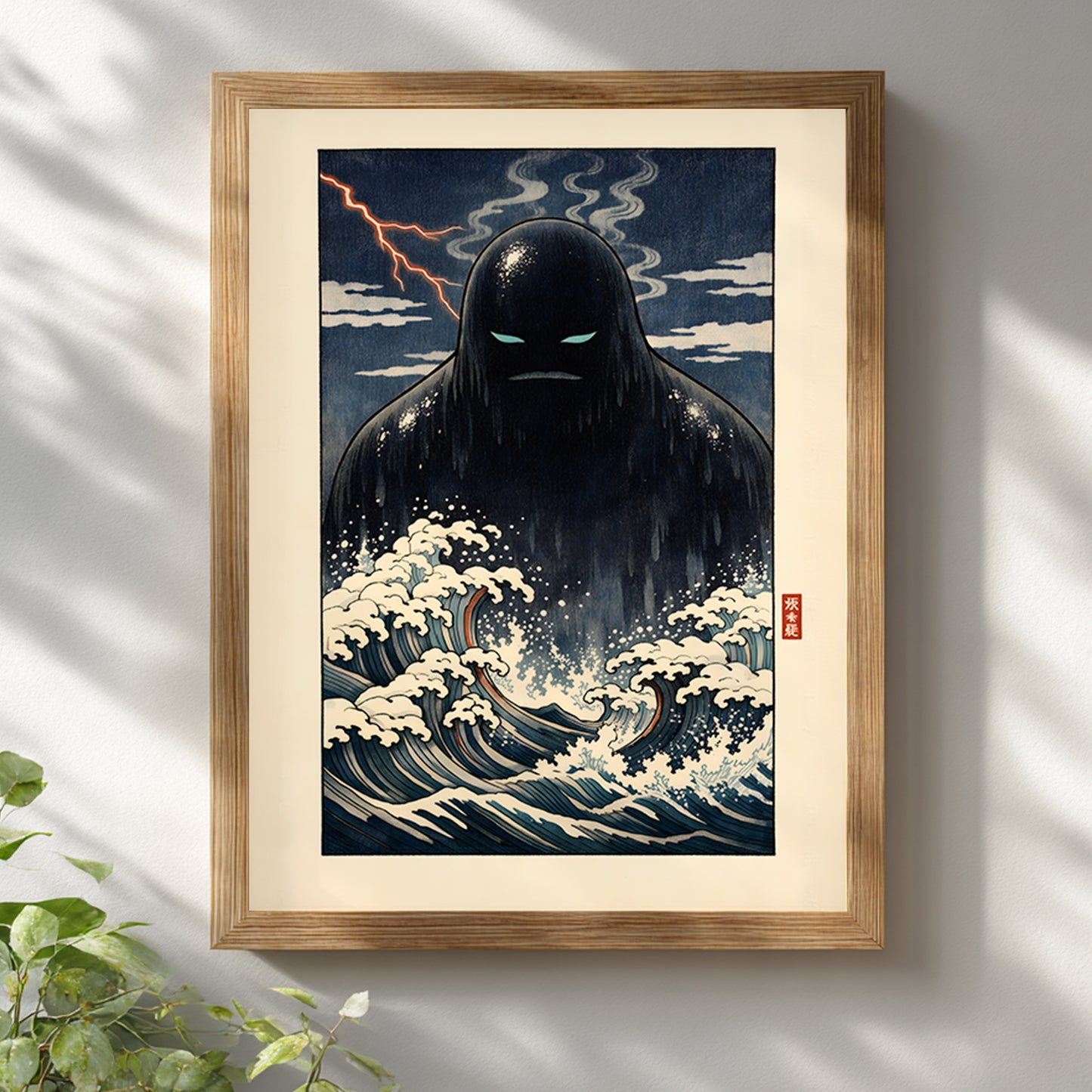 Japanese Umibōzu yōkai ocean art print displayed in a light wooden frame against a white wall. The design features a dark sea spirit rising from stylised indigo waves with cream highlights and a dramatic night sky backdrop. Inspired by classic Japanese woodblock composition, this folklore wall art adds cultural depth to modern interiors.