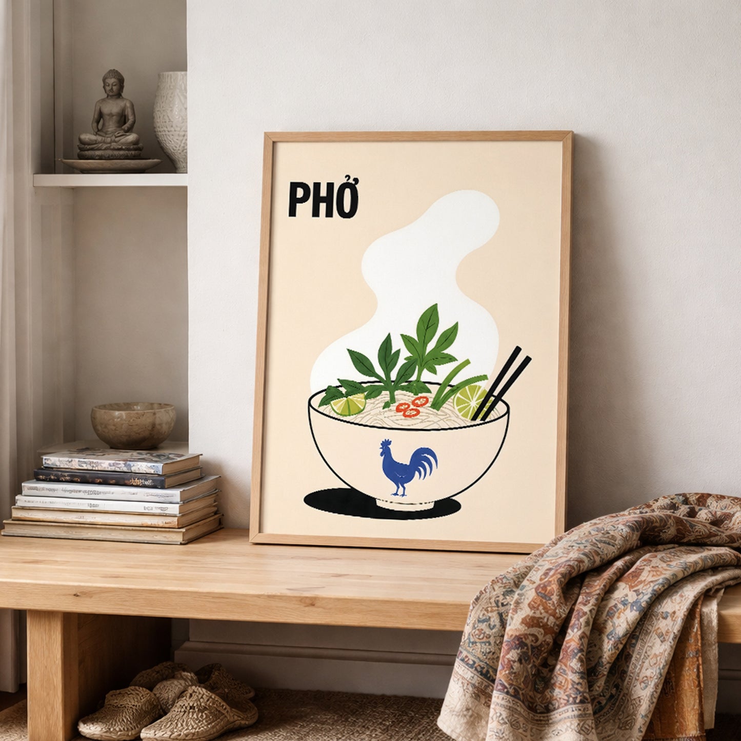 Vietnamese pho poster leaning on a shelf in a warm neutral interior beside stacked books, ceramics and a patterned textile. The food illustration features a steaming noodle bowl with herbs, lime, chilli and chopsticks.