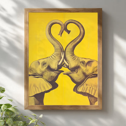 Wooden framed Elephant Heart elephant poster hung on a white wall with soft natural light and plant styling. The design shows two mirrored elephants facing inward, their trunks lifted into a heart shape in dark linework on a bold yellow background. Bright mockup for elephant wall art, elephant print, yellow elephant wall decor, framed elephant art, and modern cultural interiors.