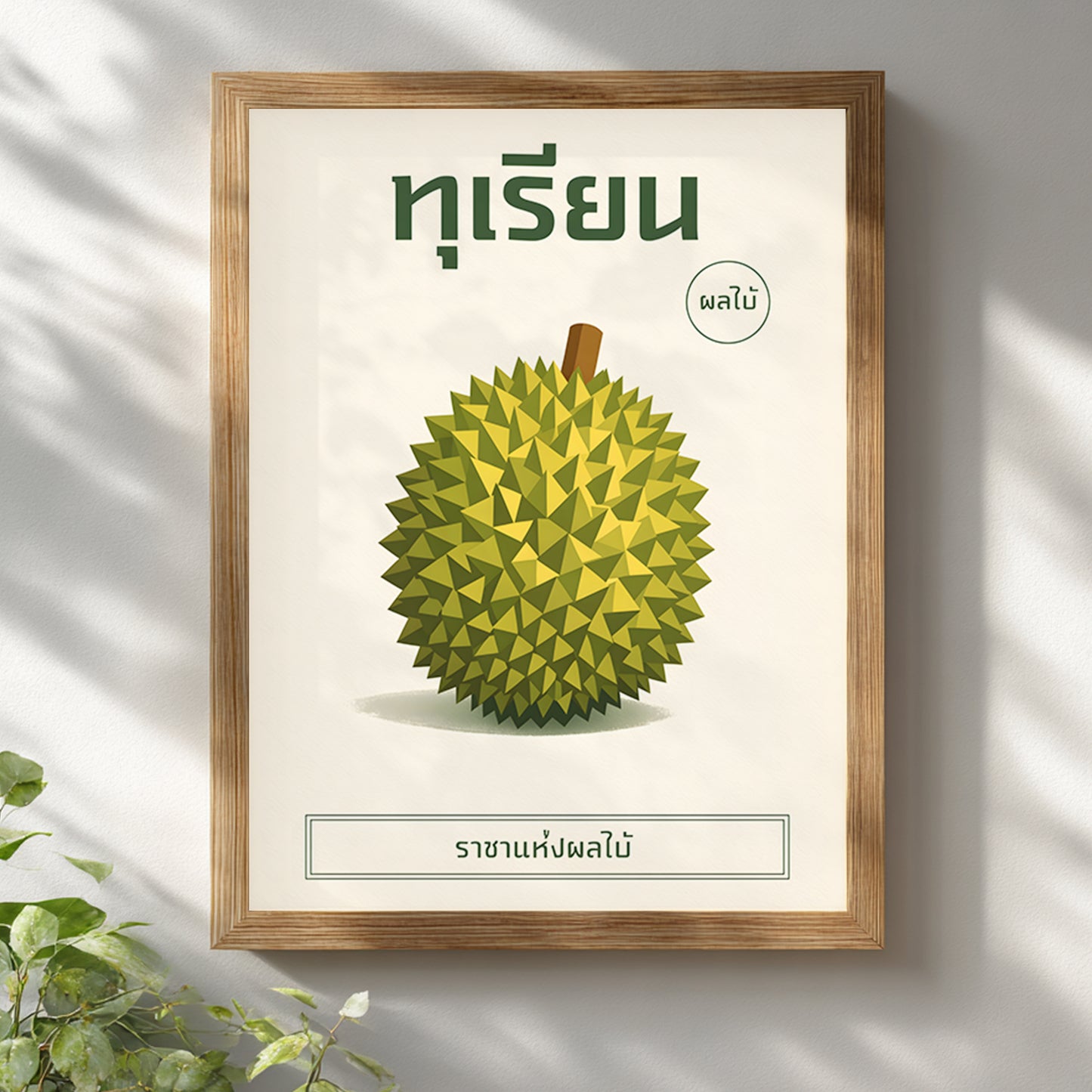Wooden framed durian botanical print mounted on a white wall with soft natural light casting shadows. The illustration features a stylised geometric green durian with Thai heading text and minimalist layout. The light wood frame adds warmth, making the artwork suitable for Scandinavian, modern or tropical-inspired interiors.
