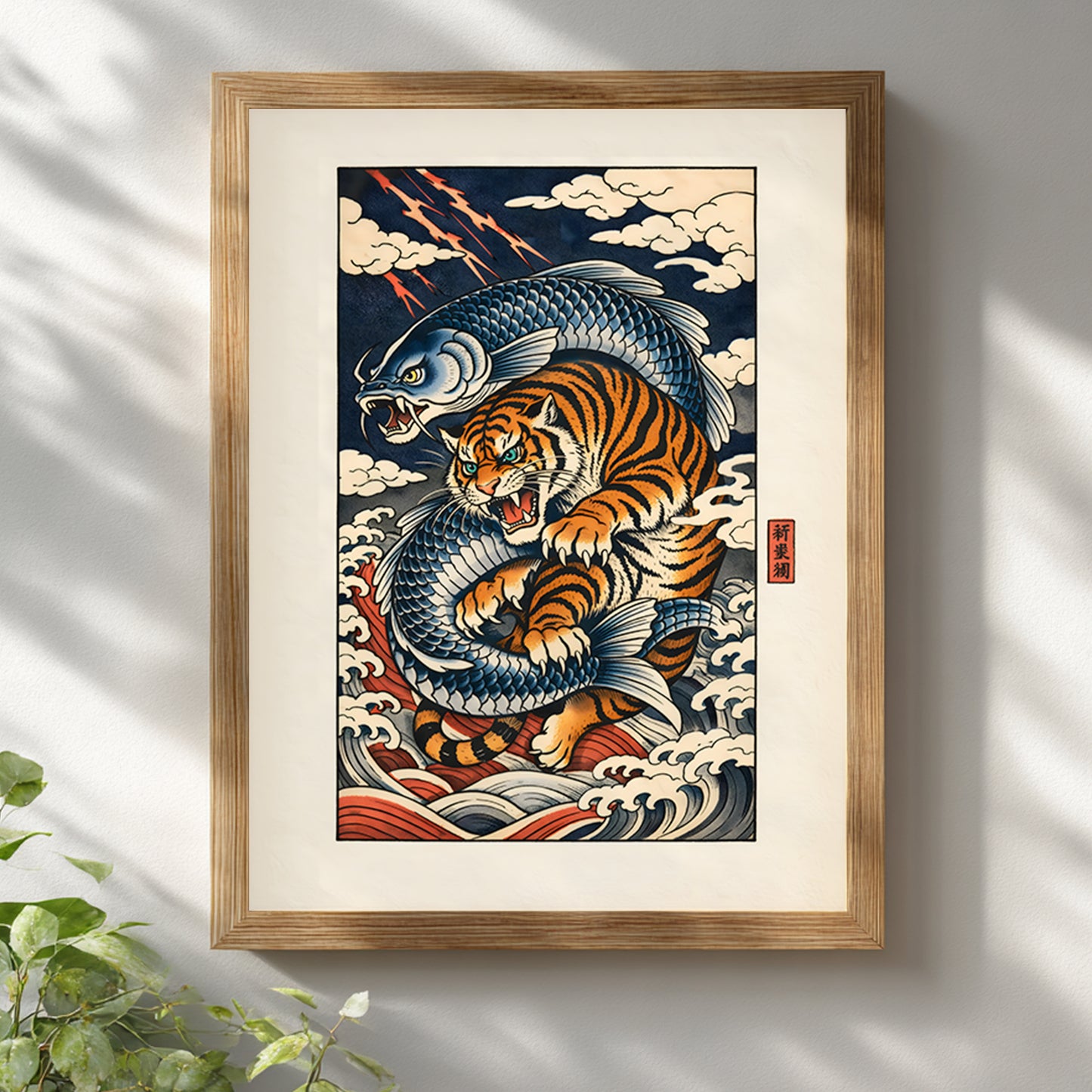 Japanese tiger and crashing wave wall art displayed in a natural wooden frame against a white wall. The bold orange tiger and swirling navy waves create dramatic contrast within the light wood frame. Inspired by traditional ukiyo-e style illustration, this framed Asian wildlife print adds warmth, movement and character to contemporary interiors.