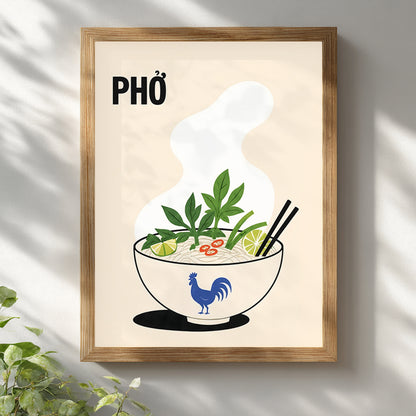 Vietnamese pho poster displayed in a light wooden frame on a white wall with soft leaf shadows. The cream kitchen print features PHỞ text, rising steam and a noodle soup bowl with herbs, lime, chilli and chopsticks.