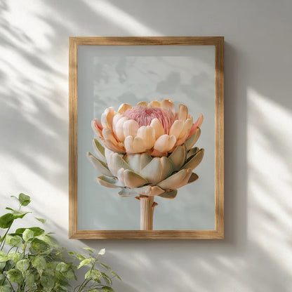 A pastel artichoke wall art print displayed in a light wooden frame on a white wall with natural daylight. The clean, airy interior setting enhances the artwork’s soft botanical tones and contemporary feel.