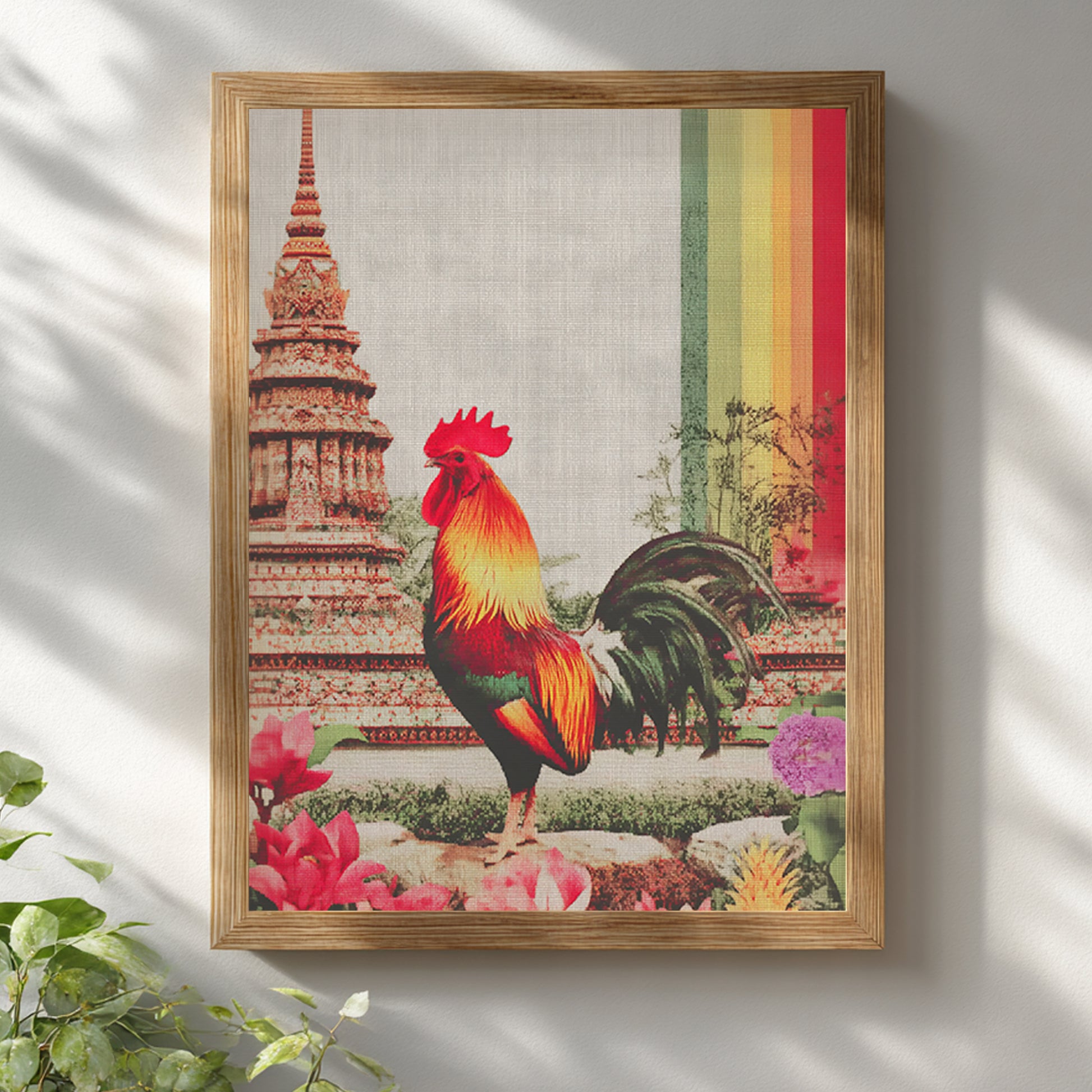 Thai rooster art print mounted on a white wall in a natural wooden frame. The colourful rooster stands before traditional temple architecture inspired by Wat Arun, with visible canvas texture and a bold vertical rainbow stripe, giving the artwork a warm organic feel suited to modern, boho, Japandi or Scandinavian interiors.